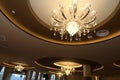 A few pendant lighting hanging from a cornice ceiling shinning warm amber golden light rays