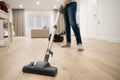 Wide angle photo of woman housewife or maid or service worker hoovering with vacuum cleaner in bright luxury appartment.