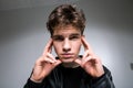 Wide angle portrait Young male model in black clothes posing in studio white background. Guy wearing black classic leather jacket Royalty Free Stock Photo