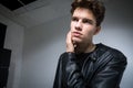 Wide angle portrait Young male model in black clothes posing in studio white background. Guy wearing black classic leather jacket Royalty Free Stock Photo