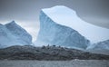 Wide-angle shooting of a group of penguins on stones surrounded by icebergs and water. Andreev.