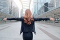 Wide angle shot of back view attractive young Asian businesswoman standing and stretching arms at urban building public background Royalty Free Stock Photo