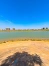 Wide angle shot of the bank of Mekong River with the Phnom Penh skyline against a clear blue sky Royalty Free Stock Photo