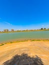 Wide angle shot of the bank of Mekong River with the Phnom Penh skyline against a clear blue sky Royalty Free Stock Photo