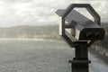 Wide angle shot of binoculars looking over the beach surrounded by mountains Royalty Free Stock Photo