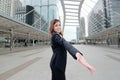 Wide angle shot of cheerful Asian businesswoman extend hand to camera at urban city background. Partnership business concept Royalty Free Stock Photo