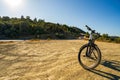 Wide angle shot of an electric bicycle parked on a dirt against highway in Greece, Europe Royalty Free Stock Photo