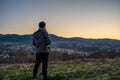 Wide angle shot of a man from behind looking at a landscape consists of mountain during sunrise in winter Royalty Free Stock Photo
