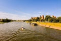 Wide angle shot of a motor boat sailing on vistula river next to wawel castle in the city of Krakow, located in Poland, Europe Royalty Free Stock Photo