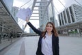 Wide angle shot of successful young Asian businesswoman raising hands and showing charts or graphs at urban building background. Royalty Free Stock Photo