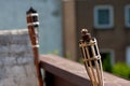 Wide angle shot of two unlit tiki torches next to each other on a building Royalty Free Stock Photo