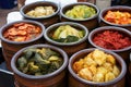 wide-angle shot of a variety of colorful kimchi in pots