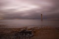 Wide angle shot of the water seen from the beach under a clouded sky Royalty Free Stock Photo
