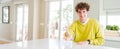 Wide angle shot of young handsome man at home smiling friendly offering handshake as greeting and welcoming Royalty Free Stock Photo