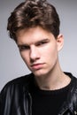 Wide angle. Studio shot. Young caucasian guy model in black clothes posing in the studio. Teenager in Leather Jacket Standing at Royalty Free Stock Photo