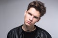 Wide angle. Studio shot. Young caucasian guy model in black clothes posing in the studio. Teenager in Leather Jacket Standing at Royalty Free Stock Photo