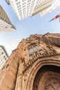 Wide angle upward view of Trinity Church at Broadway and Wall Street with surrounding skyscrapers, Lower Manhattan, New