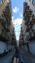 Wide angle vertically-oriented back alley of Bronx tenement apartment building with sky in New York City Royalty Free Stock Photo