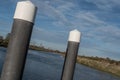 Wide angle view of a canal boat mooring platform seen within a wide expanse of water.