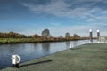 Wide angle view of a canal boat mooring platform seen within a wide expanse of water.