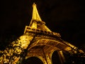 Wide-angle view of the Eiffel Tower by night.