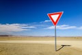 Wide angle view of a give way yield sign at a gravel road intersection in the Namibian Desert between Ai-Ais Fish River Canyon a