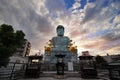 Wide angle view of the Great Buddha,Hyogo Daibutsu at Nofukuji Temple with sky,clouds and light evening sun, Kobe ,Japan