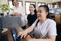 Wide angle view of happy Asian women co-workers in office workplace including person with blindness disability using computer with