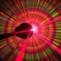 A wide angle view of a laser beam being directed through a lens with an abstract colorful diffraction pattern in the background