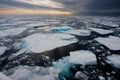 Wide angle view of Northern Arctic sea ice floes seen breaking up and melting leading into an atmospheric moody horizon with sunse