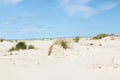 A wide angle view on the white beach sand and the blue sky with white clouds Royalty Free Stock Photo