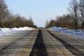Wide asphalt road, on which there are ruts from cars on the roadway