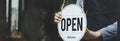 Wide banner. Reopen. waitress hand turning open sign board on glass door in modern cafe coffee shop ready to service, cafe restaur Royalty Free Stock Photo