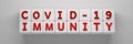 Wide banner with words Covid 19 immunity on white cubes blocks