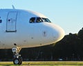 Wide-body aircraft on the runway is getting ready to take off, close-up Passenger jet plane is taxiing, side view, forest on