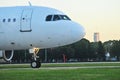 Wide-body aircraft on the runway is getting ready to take off, close-up Passenger jet plane is taxiing, side view, forest on