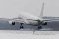 Wide-body airplane landing on runway with smoke from chassis, winter time. Touchdown with gear smoke. Aviation, transportation Royalty Free Stock Photo