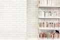 Wide book shelves against a white brick wall in a library