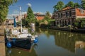 Wide canal with brick houses and boat moored on its bank reflected in water under blue sky of sunset at Weesp. Royalty Free Stock Photo