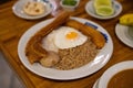 wide capture of bandeja paisa with chicharron, potato, ground beef, rice, fried egg, and a plantain at latin restaurant