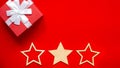 Wide Christmas banner Red gift box with a white bow in the corner, three wooden stars Royalty Free Stock Photo