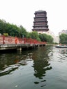 Wide clear lake river Bridge with red fence and a high antique tower