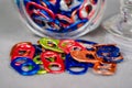 Wide close up view of a jar of multi colored can pull tabs laying on it`s side and some lying loose Royalty Free Stock Photo