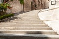 Wide concrete steps leading upward to arched entrance and turning left concrete steps rising and turning right