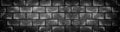 Wide dark concrete brick wall. Black shabby texture. Panoramic gloomy grunge background