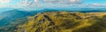 Wide drone panorama of mountain terrain and deep valleys in afternoon light Royalty Free Stock Photo