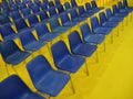 Wide empty seats rows blue chairs on yellow floor