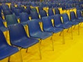 Wide empty seats rows blue chairs on yellow floor