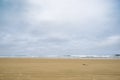 Wide expansive flat beach with tide out and low waves breaking on horizon in minimalist style inage Royalty Free Stock Photo