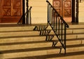 wide exterior stone stairs. deep treads and defined vertical risers. decorative painted black wrought iron railing
